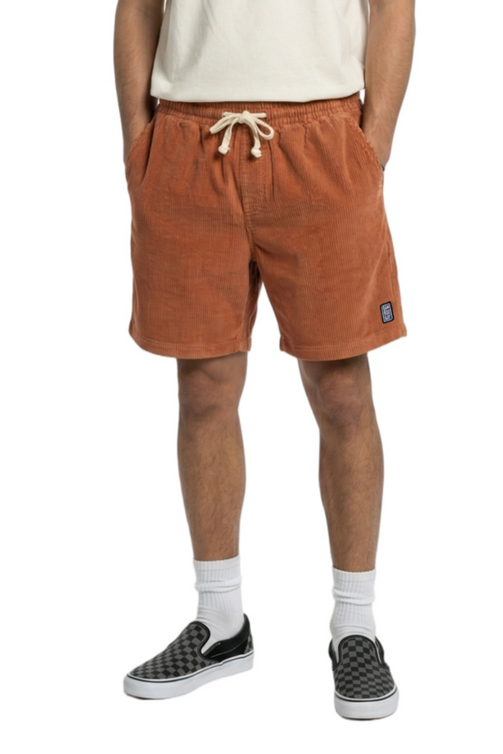 Person wearing brown shorts with a visible brand logo on a white background