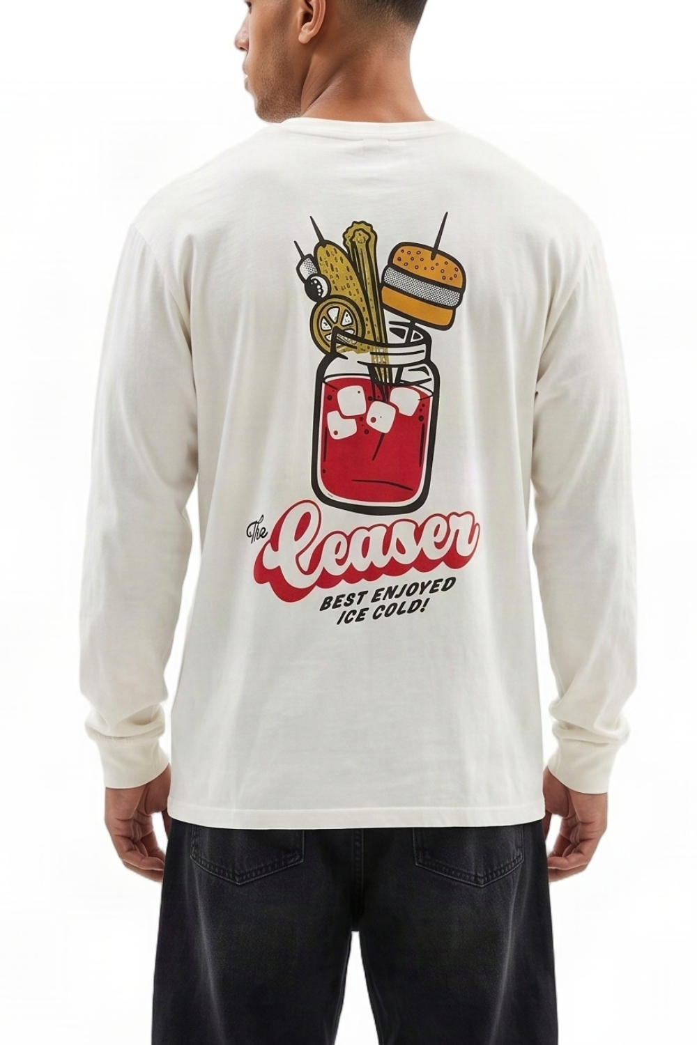 A man wearing a cream-colored long-sleeve t-shirt, viewed from the back. The shirt features a large graphic print of a mason jar cocktail with a burger on a pick, and the text 'The Ceaser' in red script with 'BEST ENJOYED ICE COLD!' underneath.