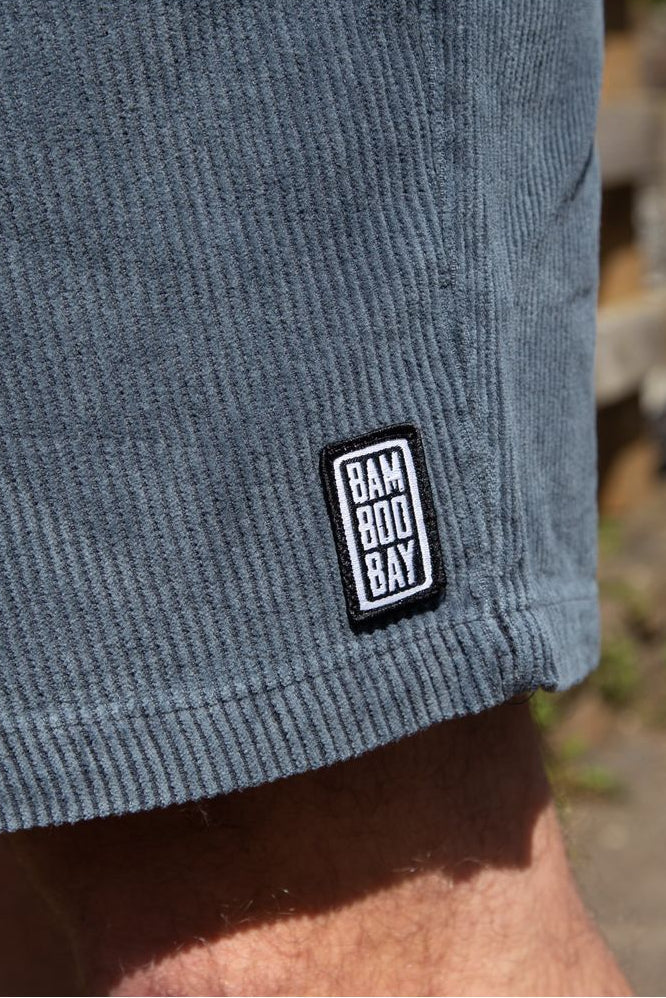 Bamboobay Navy cord shorts close up to front logo left leg on a model